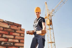 holds bricks in hands construction worker in unif 2023 11 27 04 57 33 utc 1